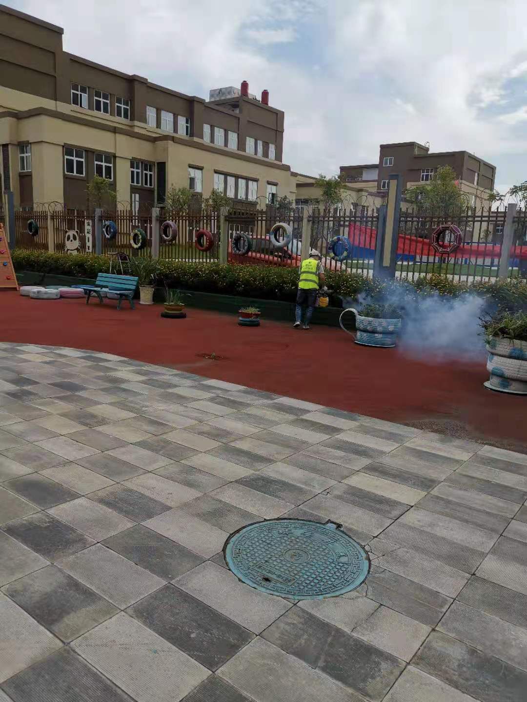 快立克环保四害消杀现场作业实拍：工作人员在庭院中，靠近灌木进行作业