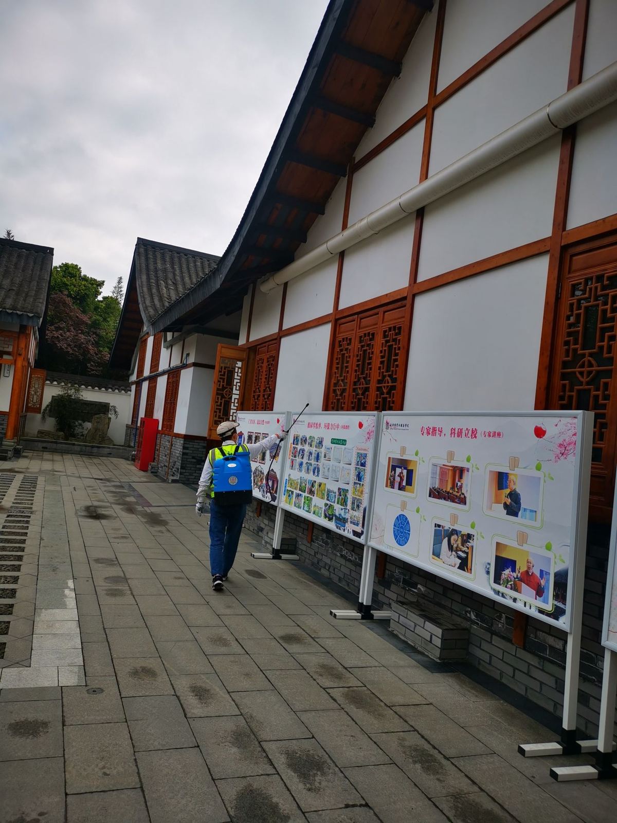 快立克环保环境或建筑现场作业实拍:建筑走廊,带有公告栏,工作人员在旁边