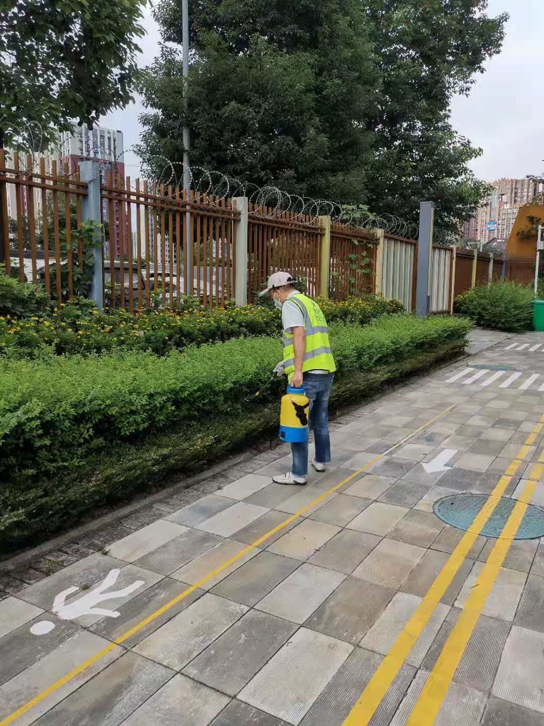 快立克环保环境或建筑现场作业实拍：工作人员在庭院中，进行清扫或维护作业
