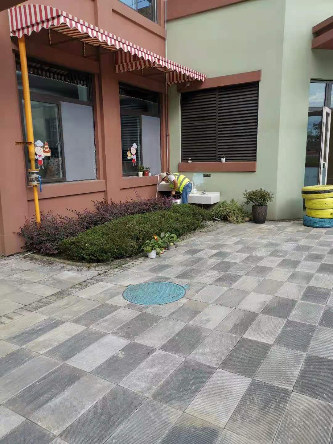 快立克环保环境或建筑现场记录：建筑外观及庭院，有绿植和道路